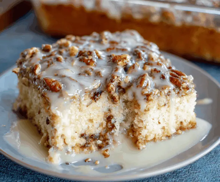 Delicious Butter Pecan Praline Poke Cake topped with toasted pecans and caramel glaze, perfect for dessert lovers