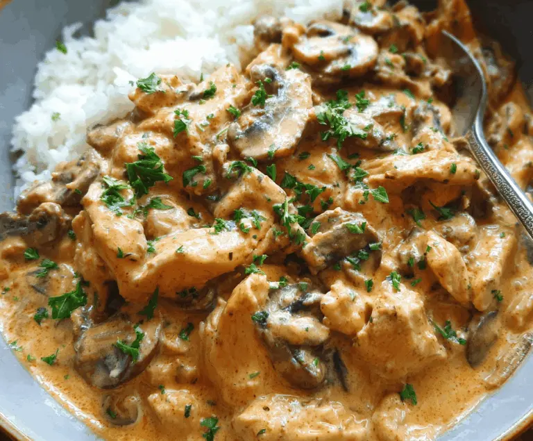 Creamy Chicken Stroganoff served over noodles with mushrooms and herbs, featuring tender chicken pieces in a rich sauce.