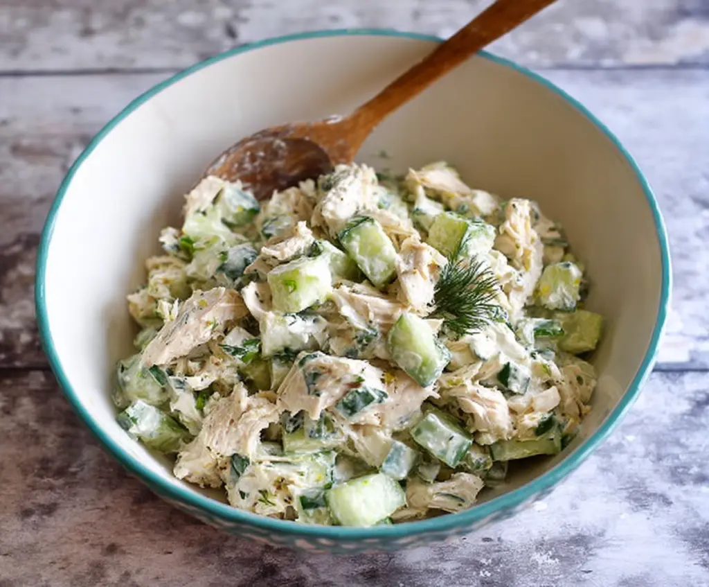 Fresh cucumber dill Greek yogurt rotisserie chicken salad served in a bowl, garnished with herbs and lemon for a healthy, flavorful meal.