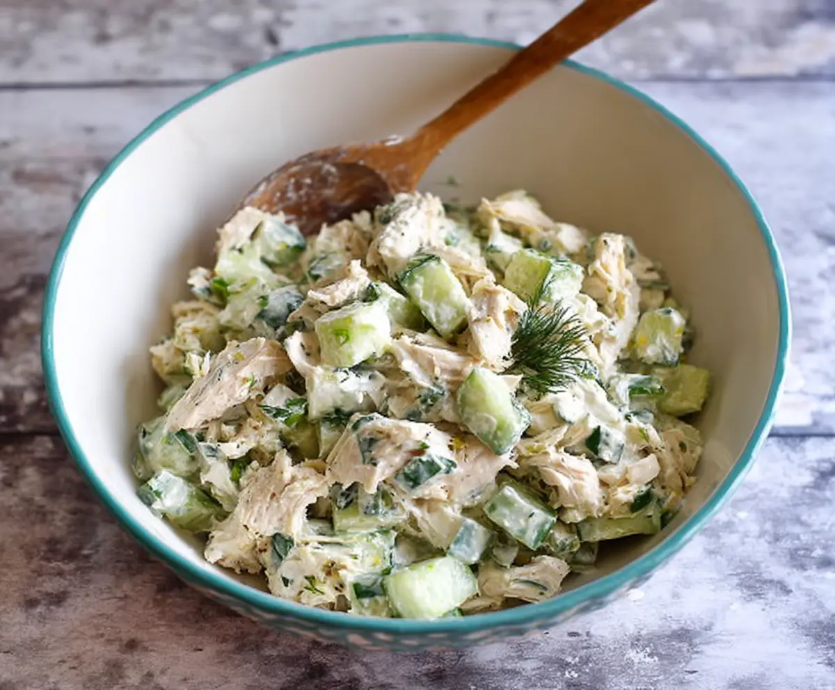 Fresh cucumber dill Greek yogurt rotisserie chicken salad served in a bowl, garnished with herbs and lemon for a healthy, flavorful meal.