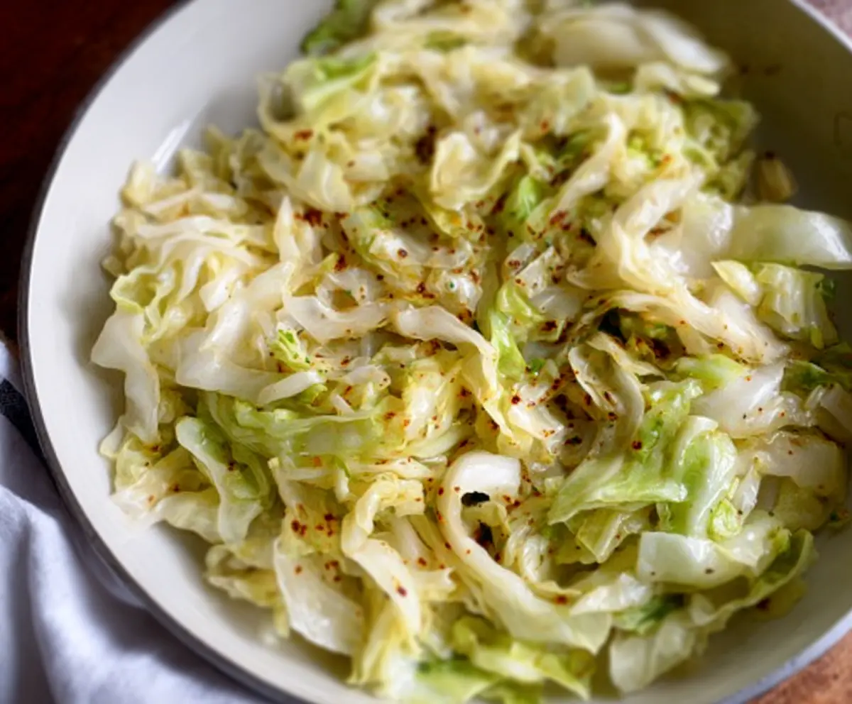 Delicious garlic butter sautéed cabbage served on a plate, showcasing caramelized edges and vibrant green color.