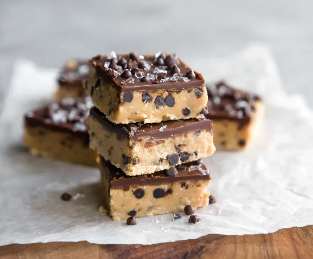 Healthy no-bake cookie dough bars with chocolate chips and nuts in a clear glass dish