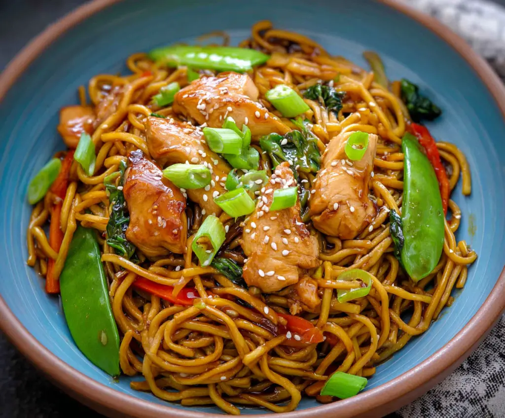 Delicious Chicken Teriyaki Noodles garnished with green onions on a plate.