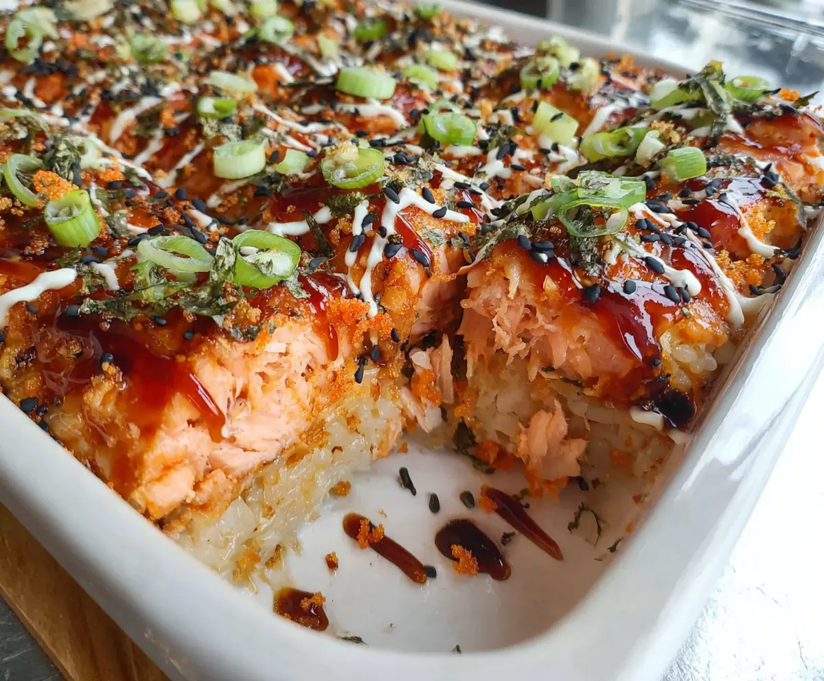 Delicious spicy salmon sushi bake topped with fresh ingredients and crispy toppings.