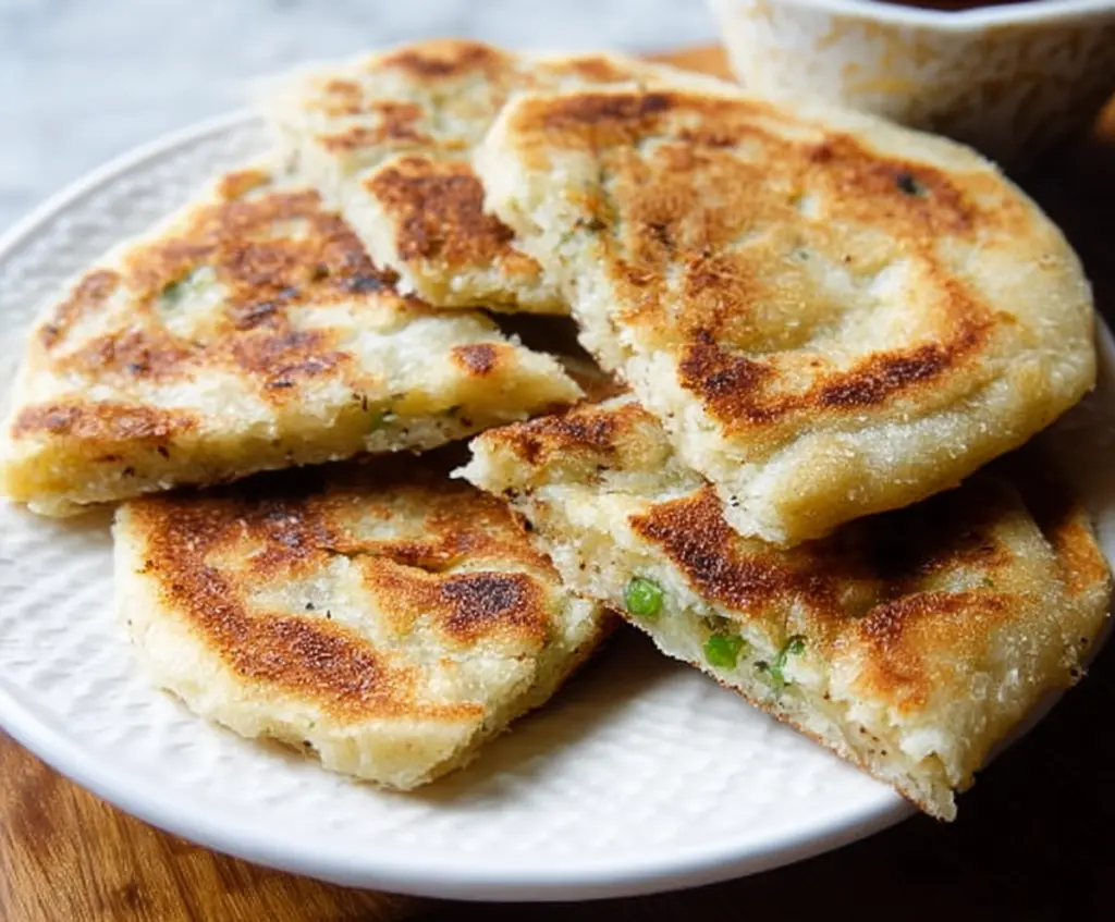 Close-up of traditional Irish Potato Farls on a rustic wooden board, highlighting their golden-brown crust and soft interior.