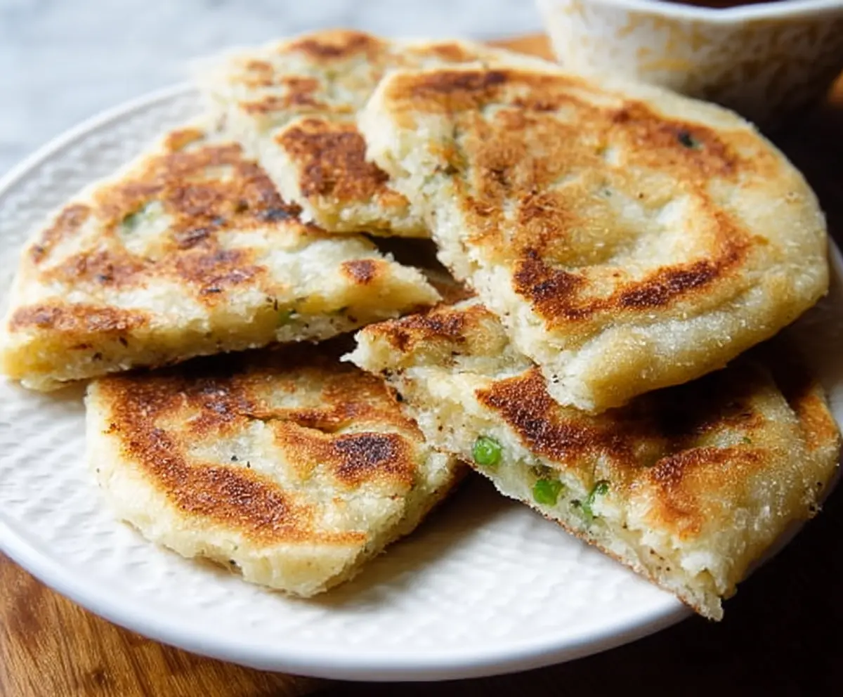 Close-up of traditional Irish Potato Farls on a rustic wooden board, highlighting their golden-brown crust and soft interior.