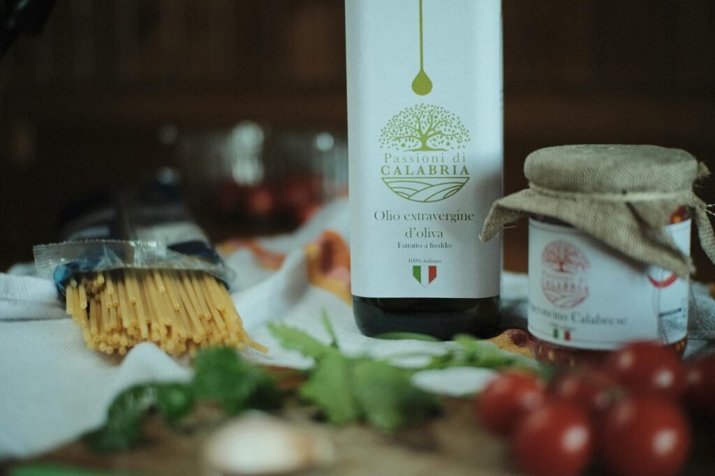 Dry pasta, jarred sauce, garlic, olive oil, and Parmesan on a kitchen counter beside a grocery receipt
