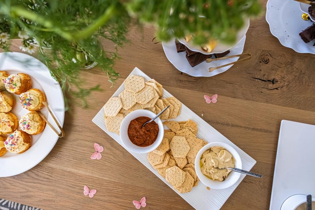 A modest bridge snack platter with hummus, pita, carrots, and crackers.