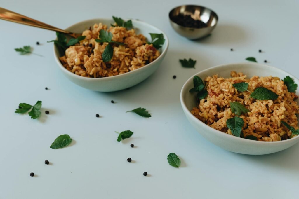 Chicken, rice, and bean bowls topped with yogurt sauce, parsley, and lemon.