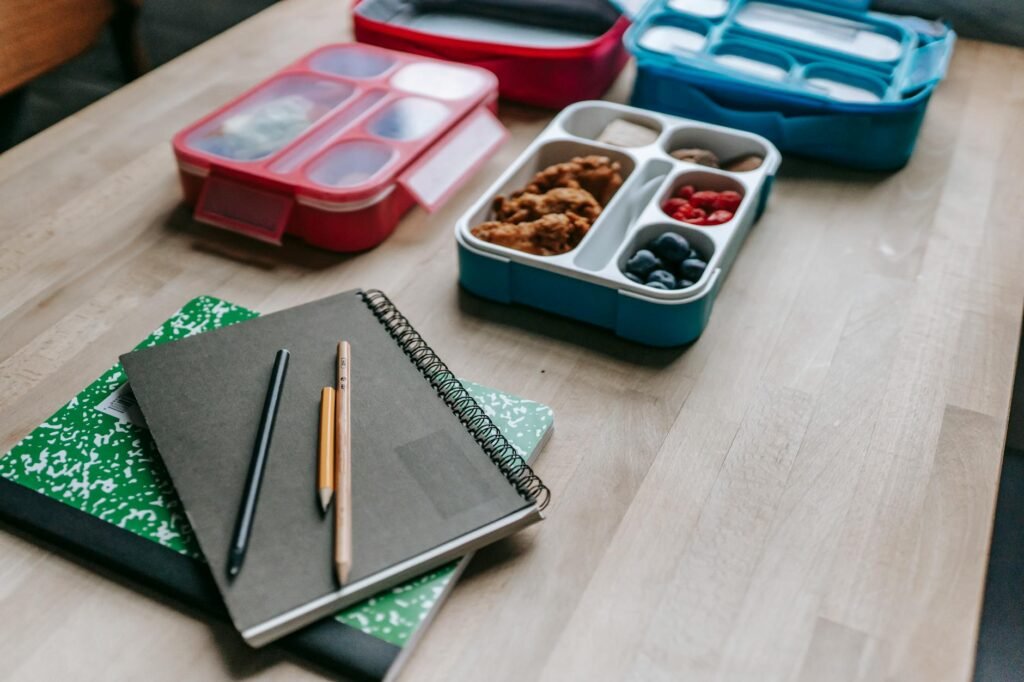 A grocery receipt, calculator, and lunch container on a table during meal planning