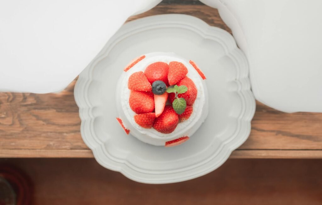 Slice of angel food cake topped with berries and cream