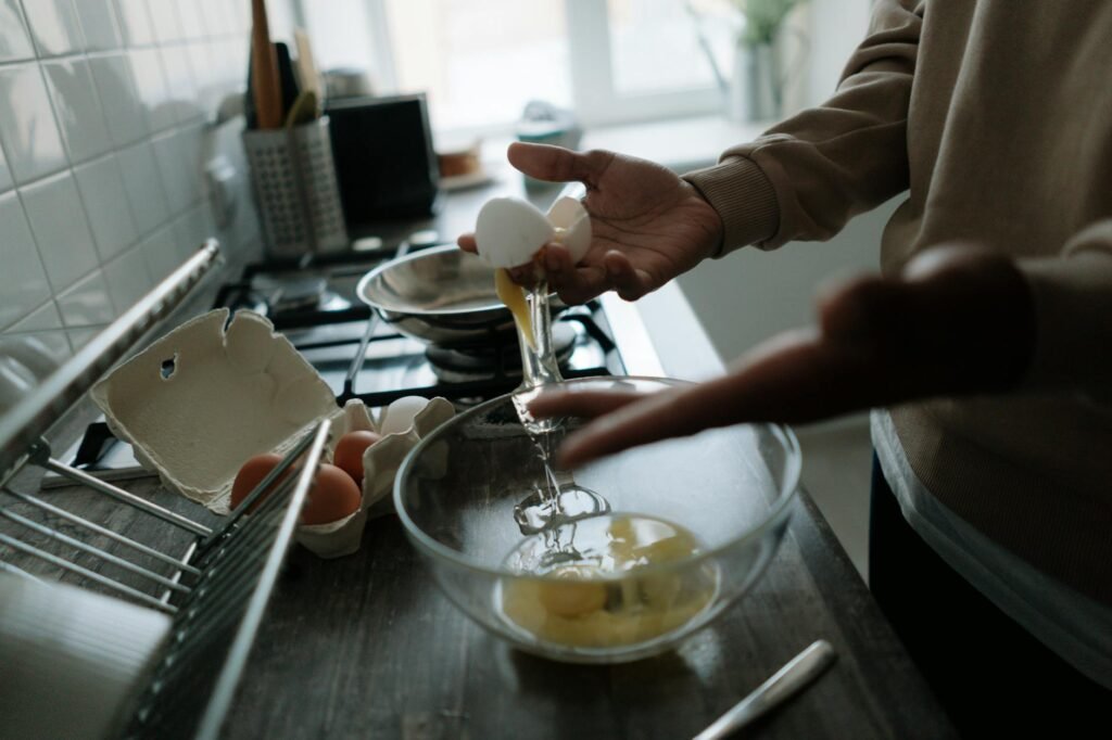 A grocery list and calculator beside basic brunch ingredients on a kitchen counter