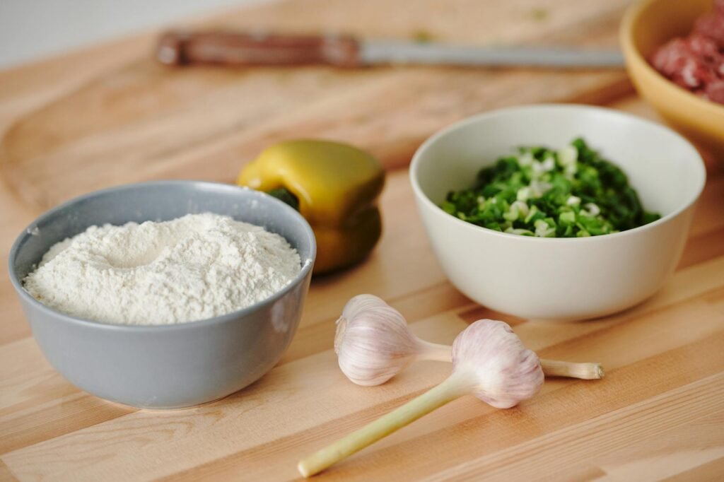 Onion, garlic, lemon, herbs, canned beans, and rice arranged on a clean kitchen counter.
