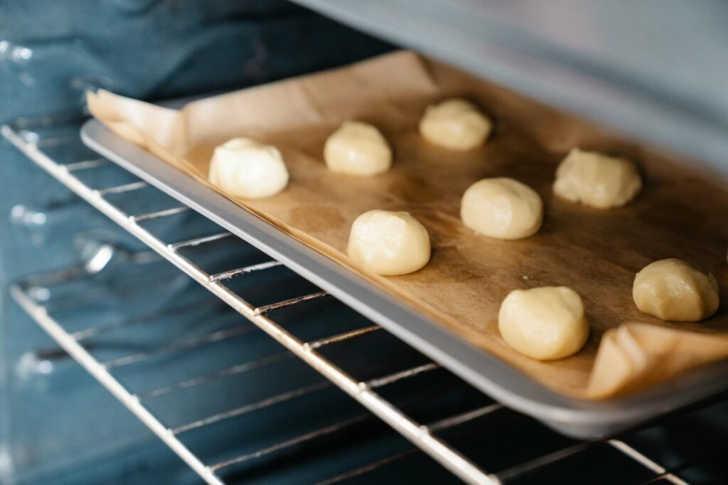Scooped cookie dough resting on a parchment-lined baking sheet before baking