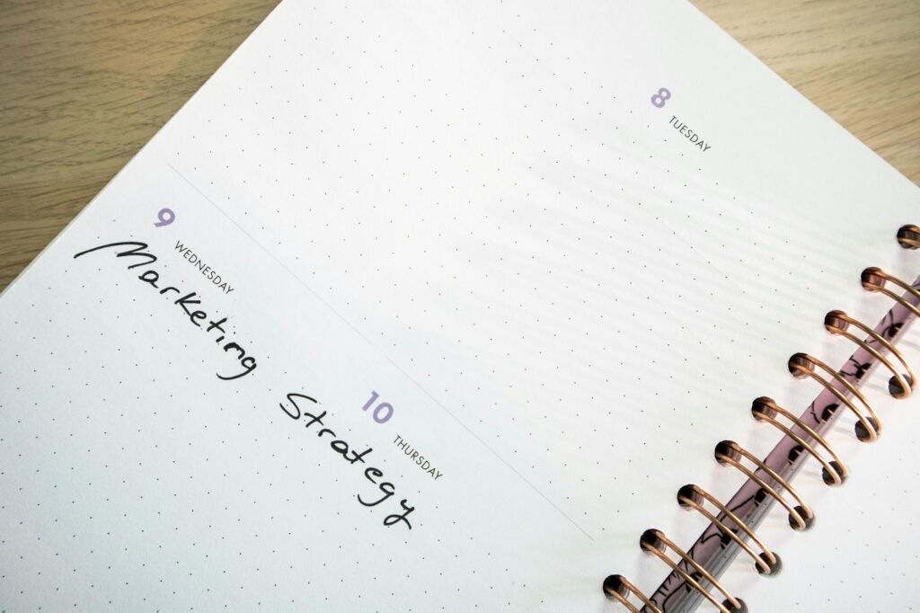 A weekly calendar and grocery list beside a few ingredients on a kitchen counter