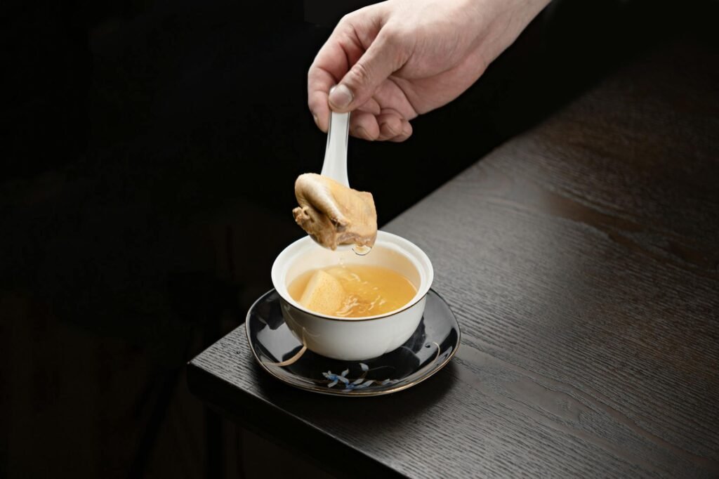 A spoon scraping browned bits from the bottom of a skillet