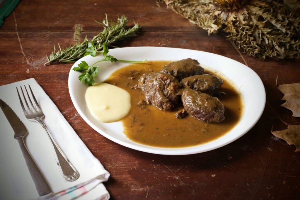 A tasting plate with mashed potatoes and several spoonfuls of gravy for comparison.