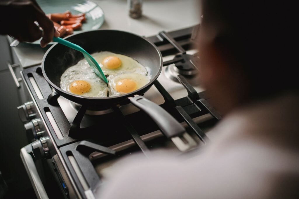 A skillet of fried rice with vegetables and eggs cooking on a stovetop
