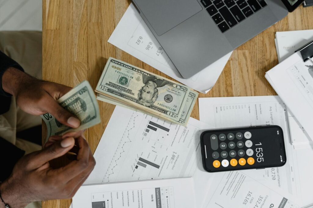 A calculator and grocery receipts next to produce on a kitchen table