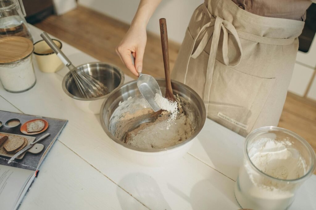 Butter, flour, stock, measuring spoons, and pan drippings arranged for making gravy.